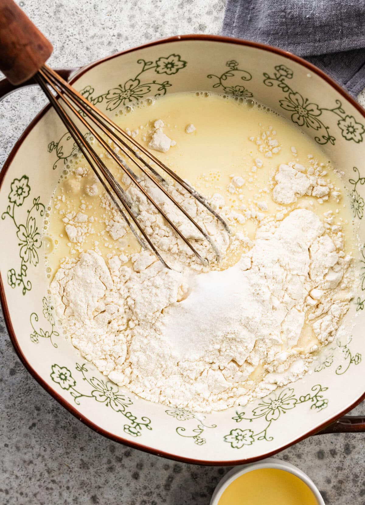 flour being whisked into the bowl of batter.