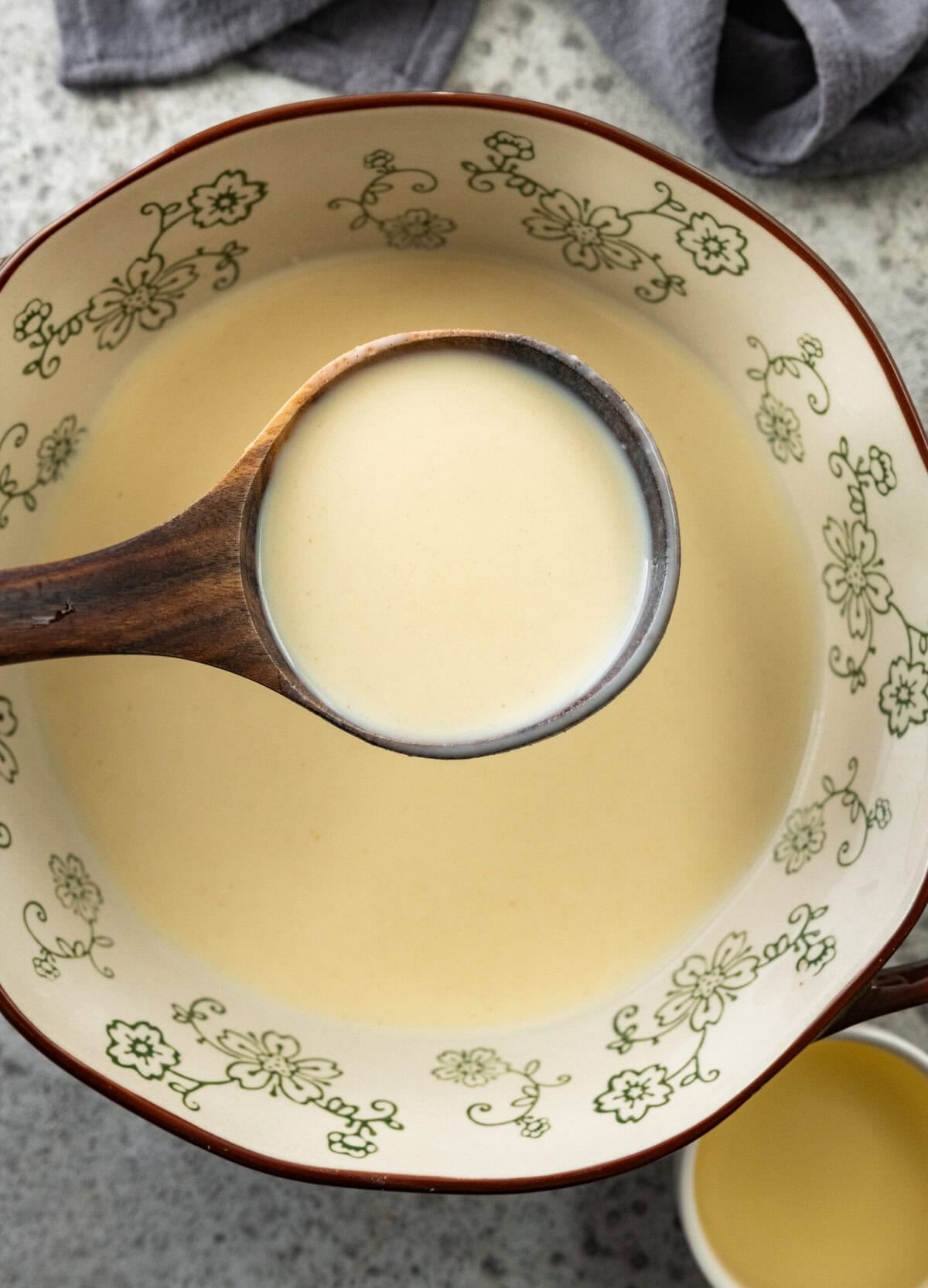 a scoop of batter being held up over the bowl of batter.