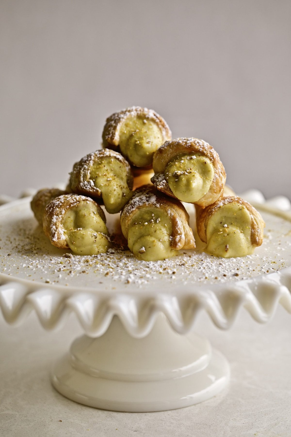Cream horns stacked on a raised platter.