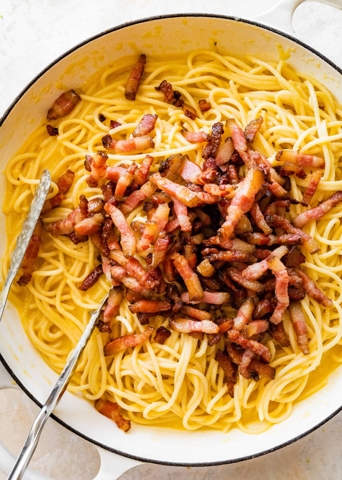 Cooked guanciale added to the spaghetti in carbonara sauce.