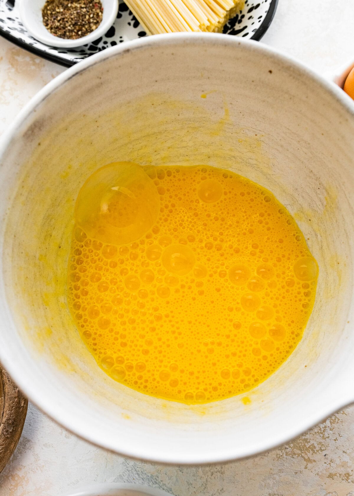 Eggs whisked together in a bowl.