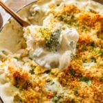 cheese and broccoli pasta bake in a pot, with a fork holding some.