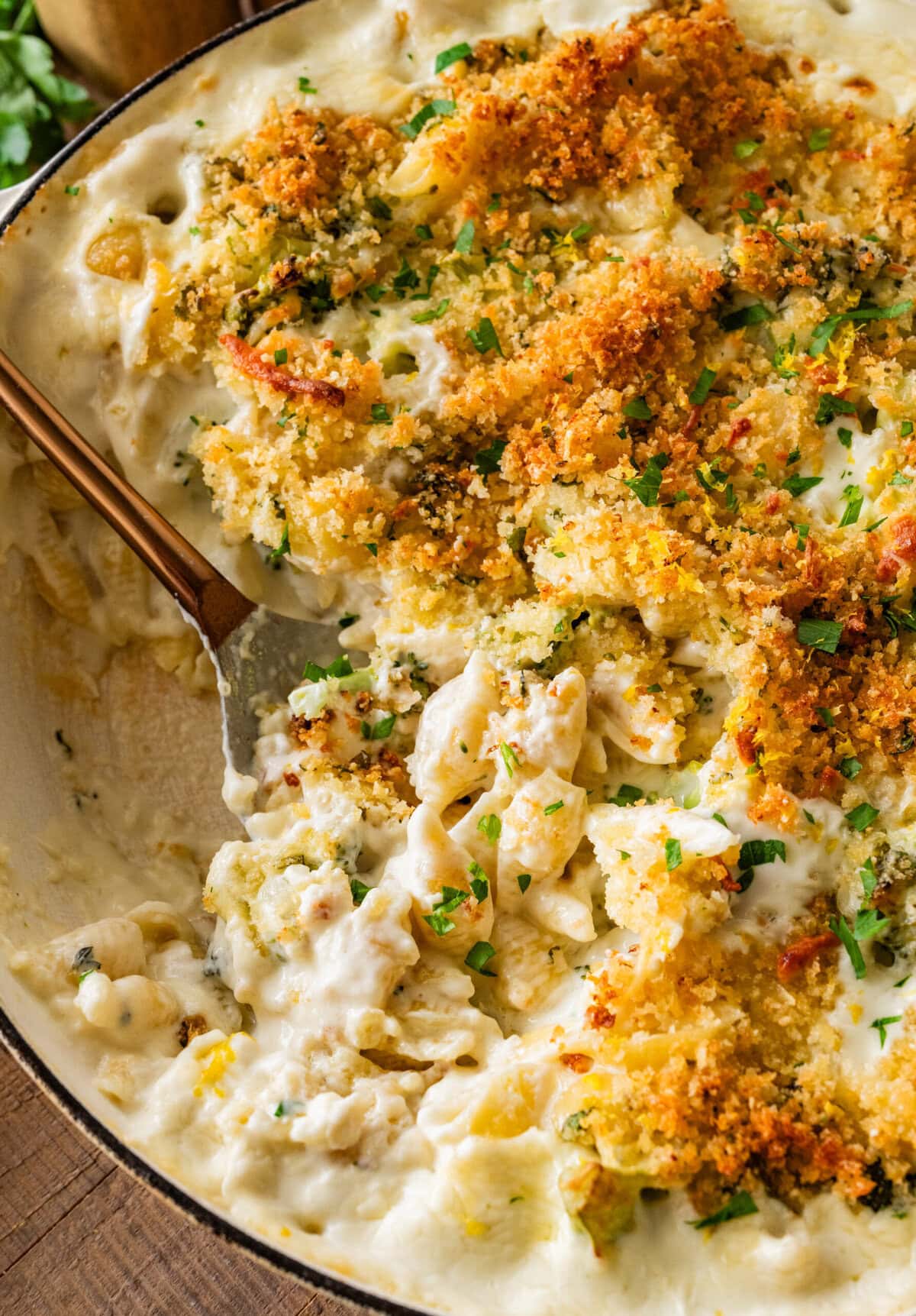 cheese and broccoli pasta bake in a pot, with a fork holding some.