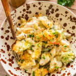 cheese and broccoli pasta bake in a dish, with a fork resting inside of it.