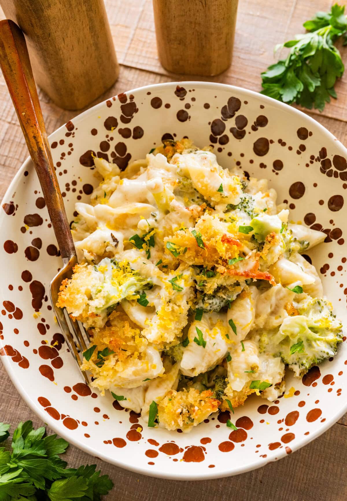 cheese and broccoli pasta bake in a dish, with a fork resting inside of it.
