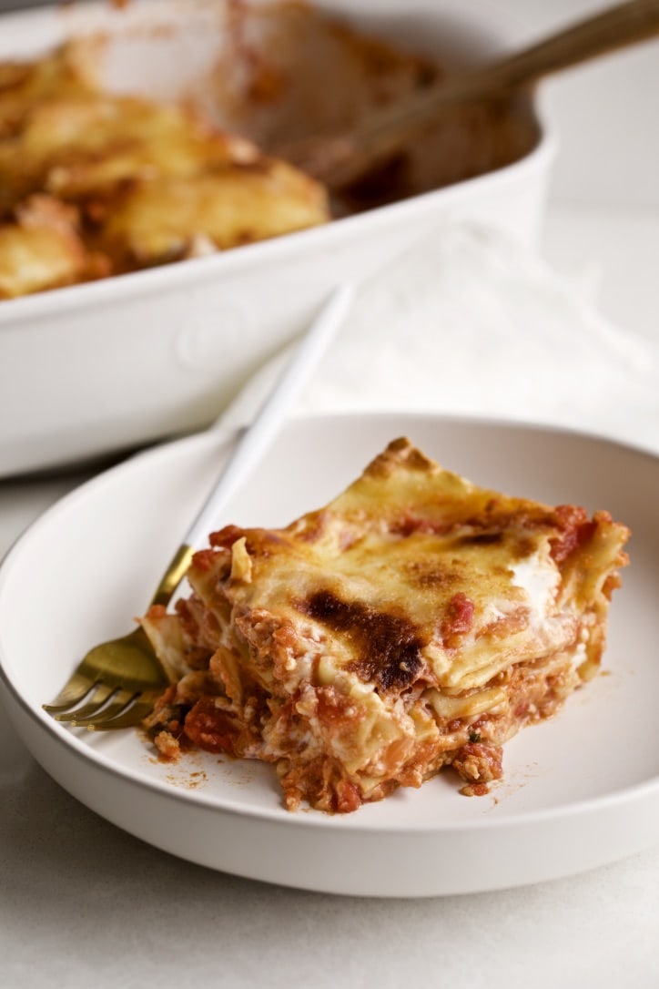 a slice of lasagna on a plate with a fork