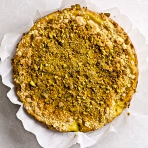 Italian Crumb Cake with Pistachio Cream (Sbriciolata) the entire cake photo taken from above. Parchment paper surrounds the cake.