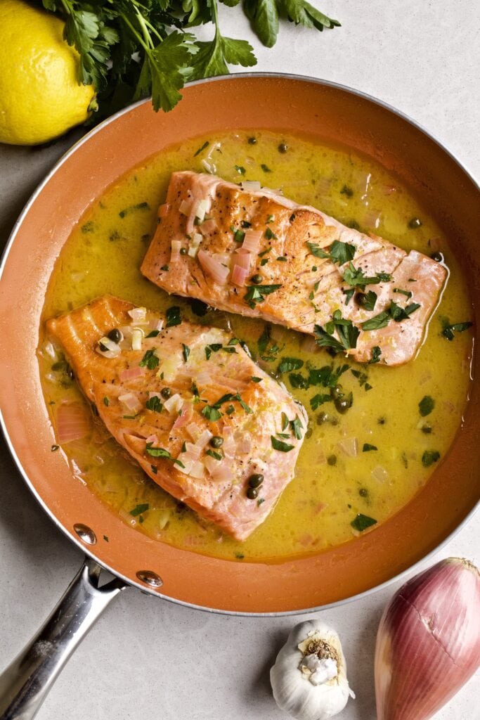 Salmon Piccata in a pan on a counter.