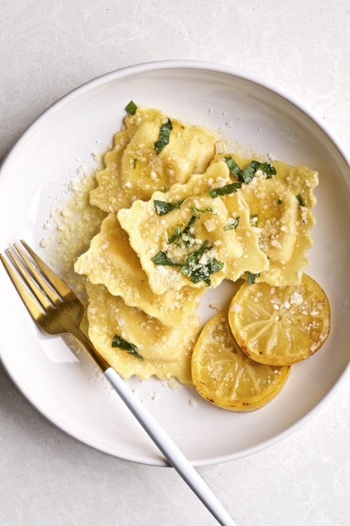 Lobster ravioli on a white plate and a fork.