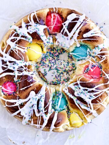 Downward shot of braided Easter bread with colorful eggs whole cake with lots of colorful sprinkles.