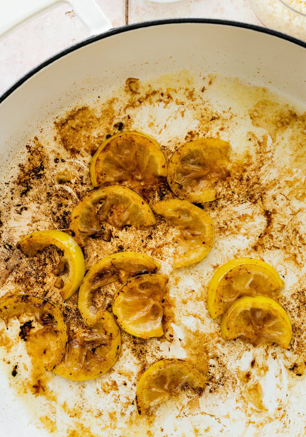 Lemons and butter cooked in a white skillet.