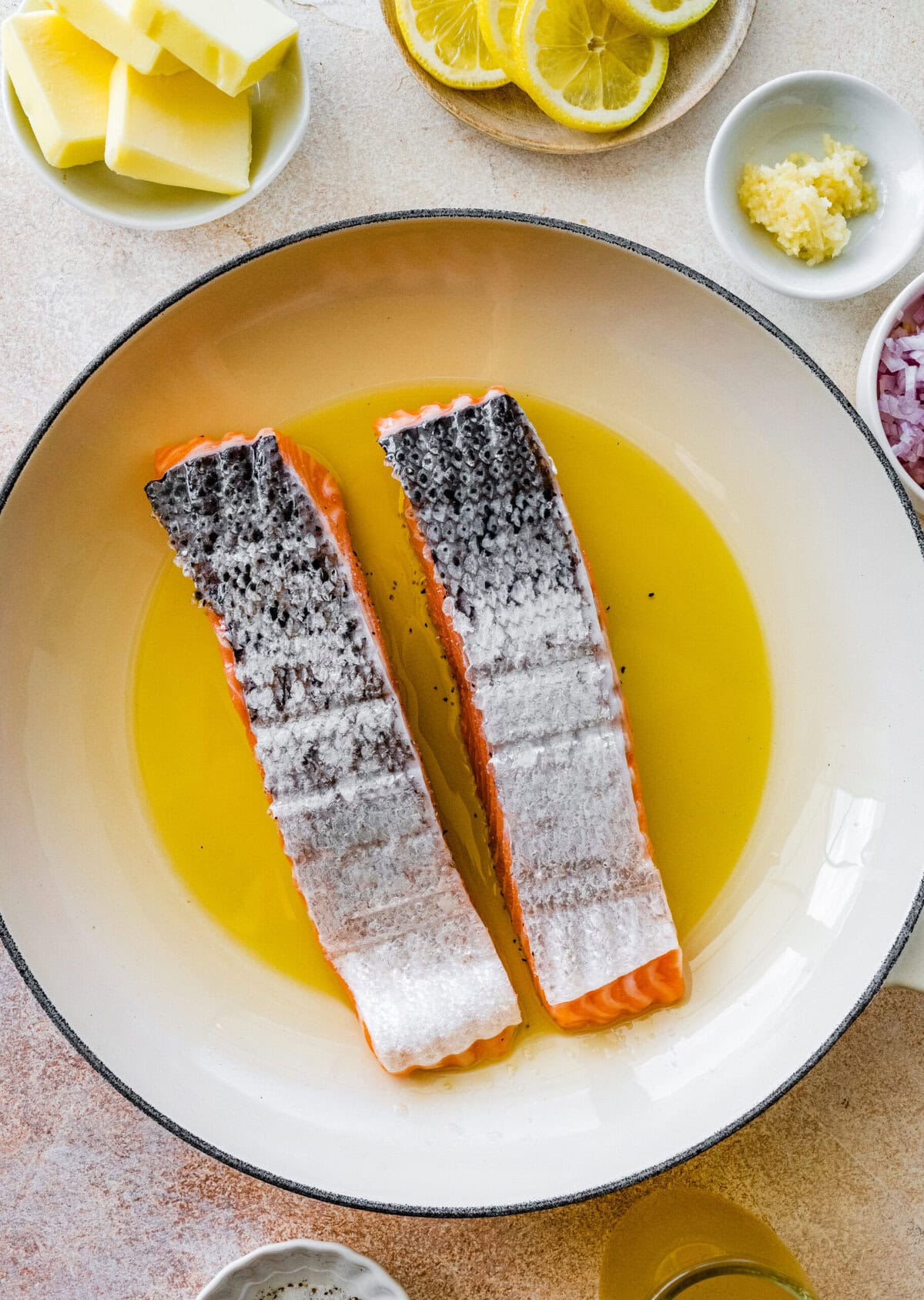 Salmon skin side up cooking in a pan.