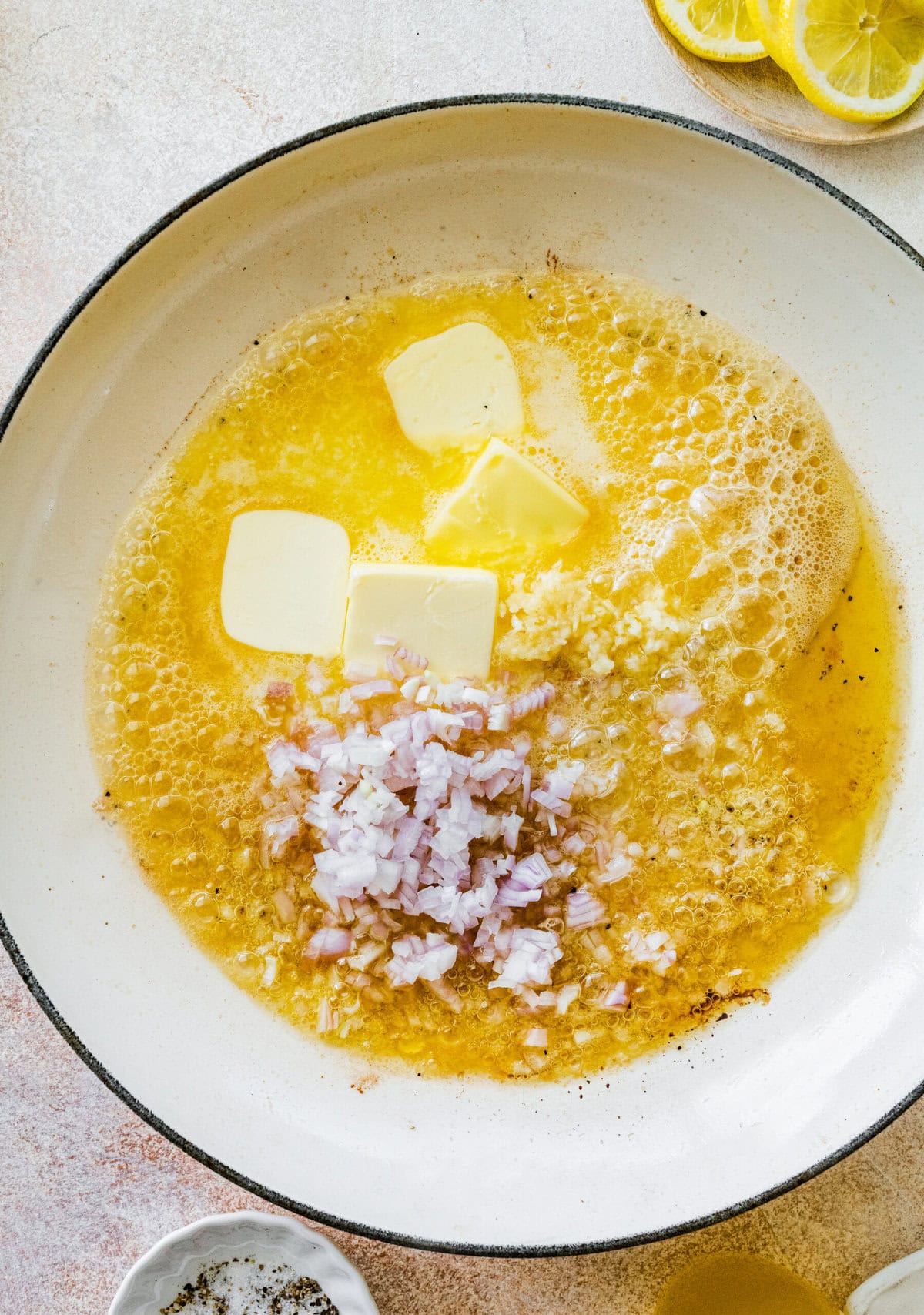 Ingredients to make piccata sauce added to the skillet.