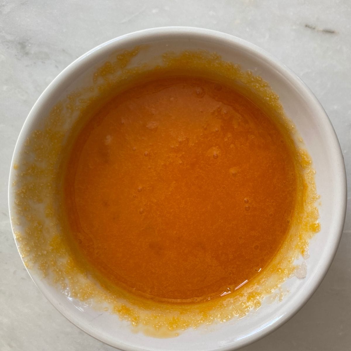 Egg yolks and sugar mixed in a bowl.