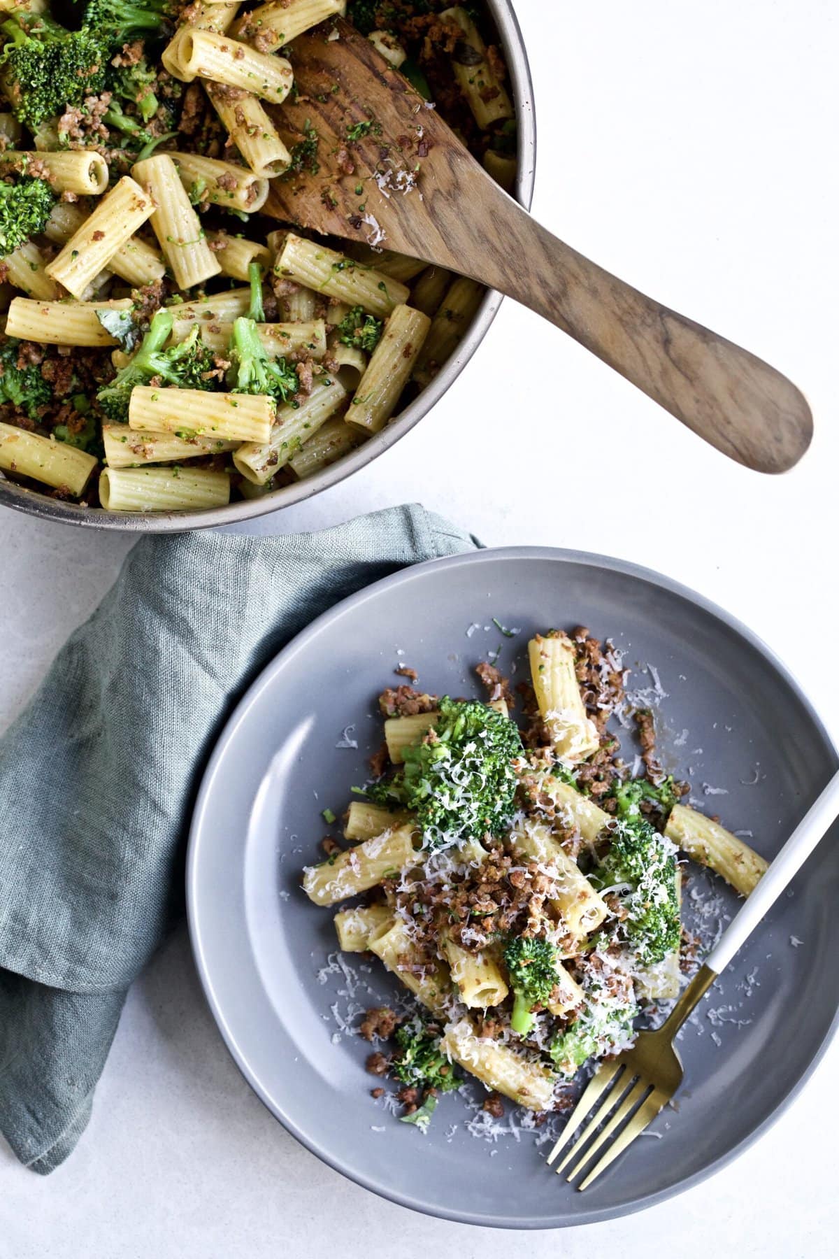 Broccoli Pasta with Sausage Recipe (Italian)- on a plate with a fork. Pan in the background.