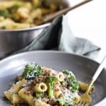 Broccoli Pasta with Sausage Recipe (Italian)- on a plate with a fork. Pan in the background.