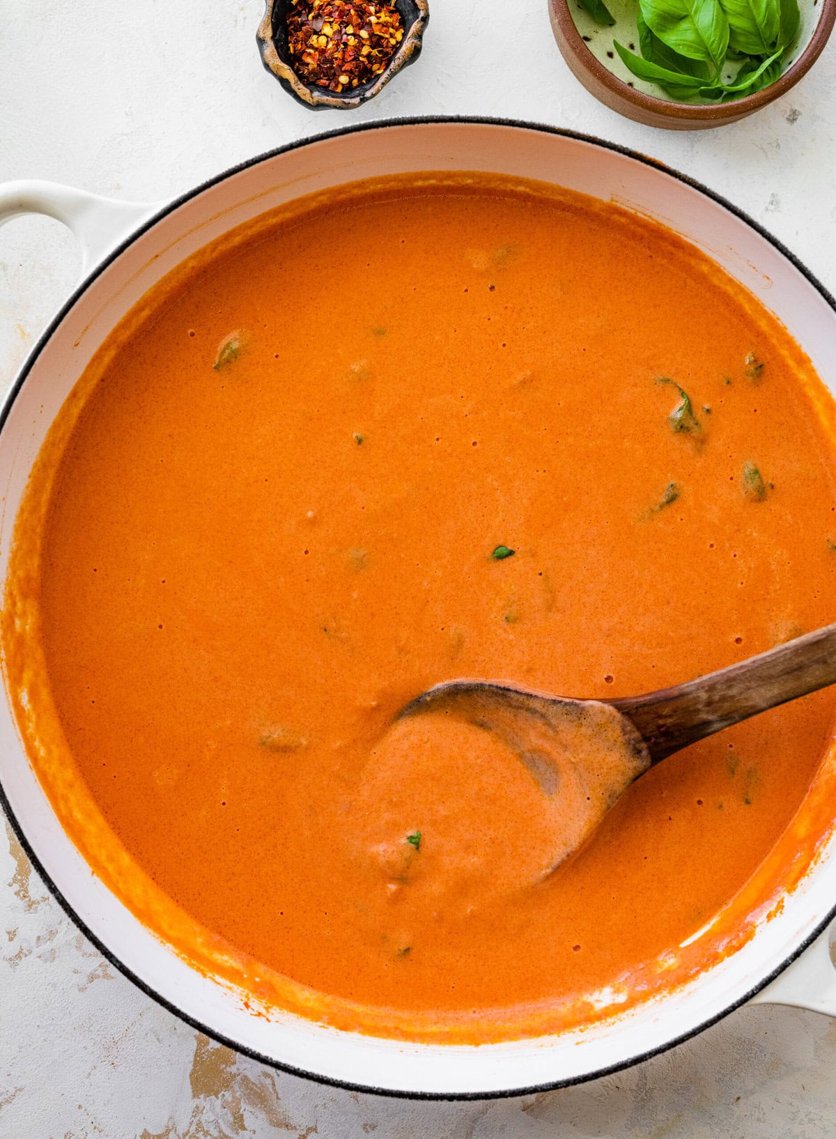 pan with sauce and fresh basil.