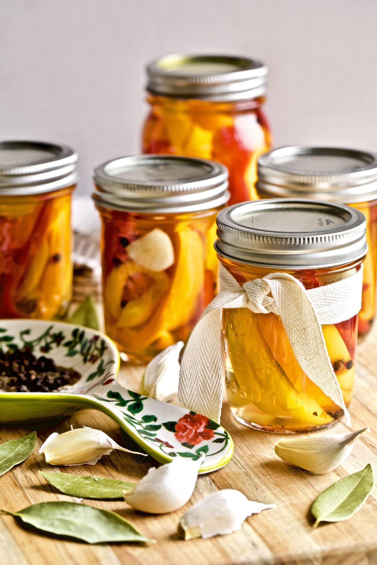 Italian vinegar peppers in a jars with ingredients and serving spoon  with ingredients 
