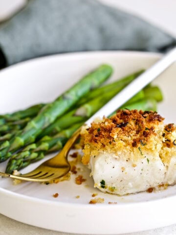 Crispy Baked Cod with Panko Recipe on a plate with asparagus