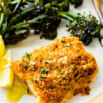 crispy baked cod with panko on a plate with broccolini.
