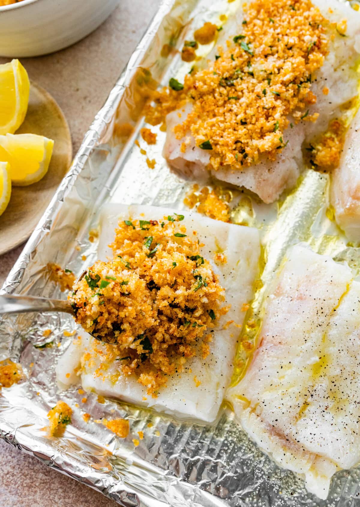 add the bread crumb mixture to the cod on the baking sheet.