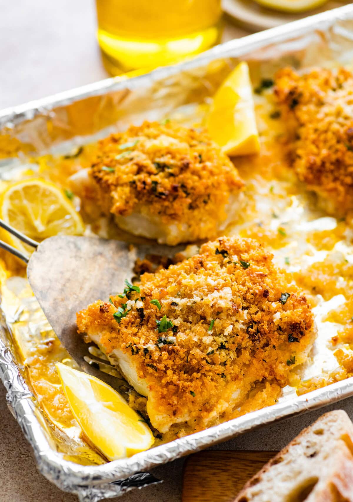 spatula lifting the crispy panko crusted cod from the pan.