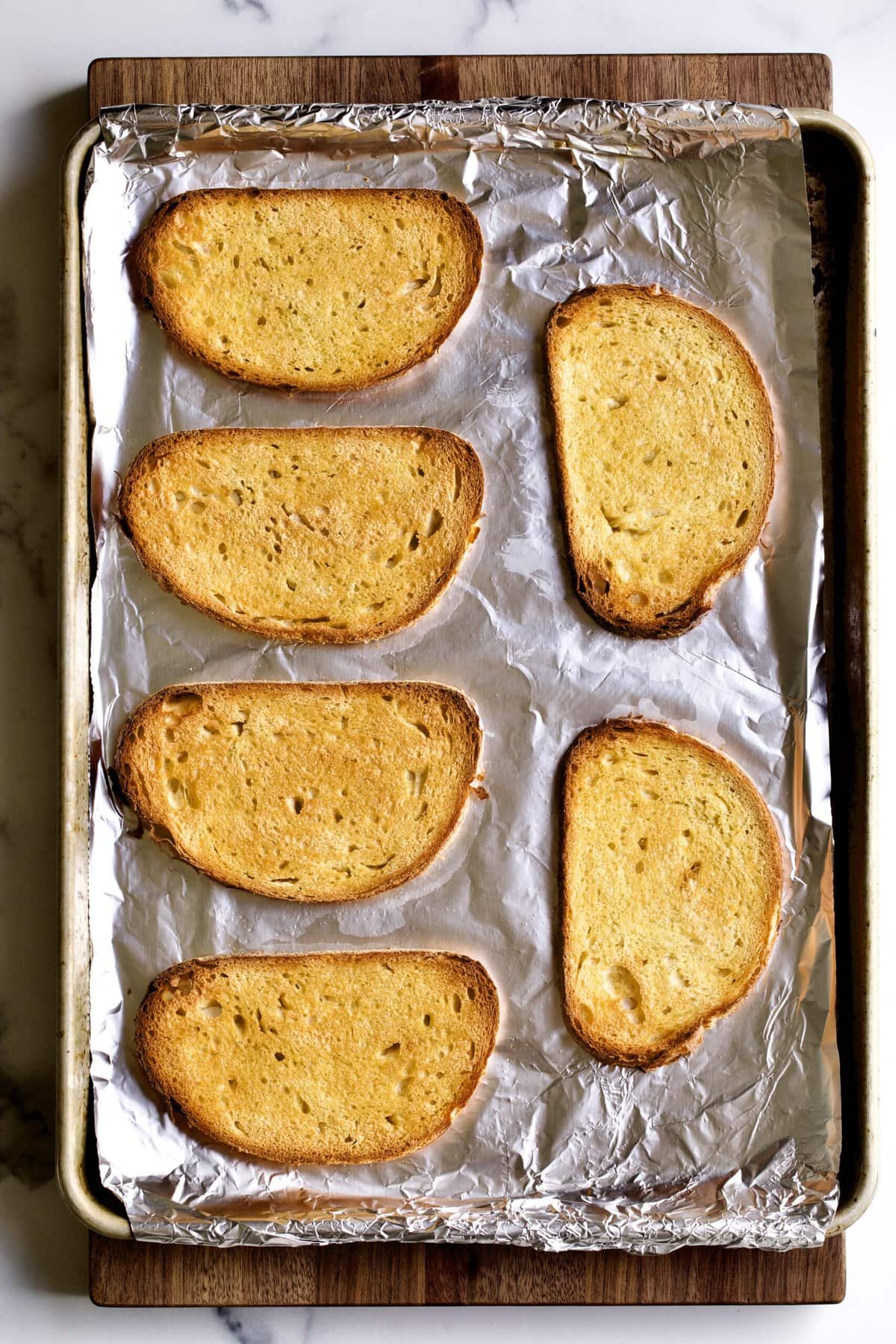 grilled bread on baking sheet. 