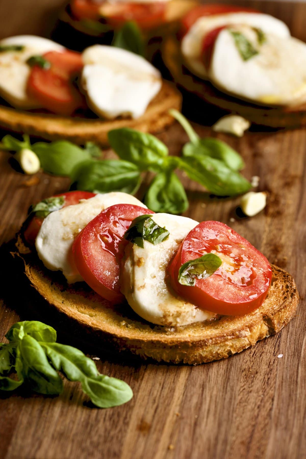 Easy Bruschetta Recipe with Mozzarella and Tomato Basil hand holding one. 