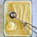Italian pistachio gelato in glass container with ice cream scoop.