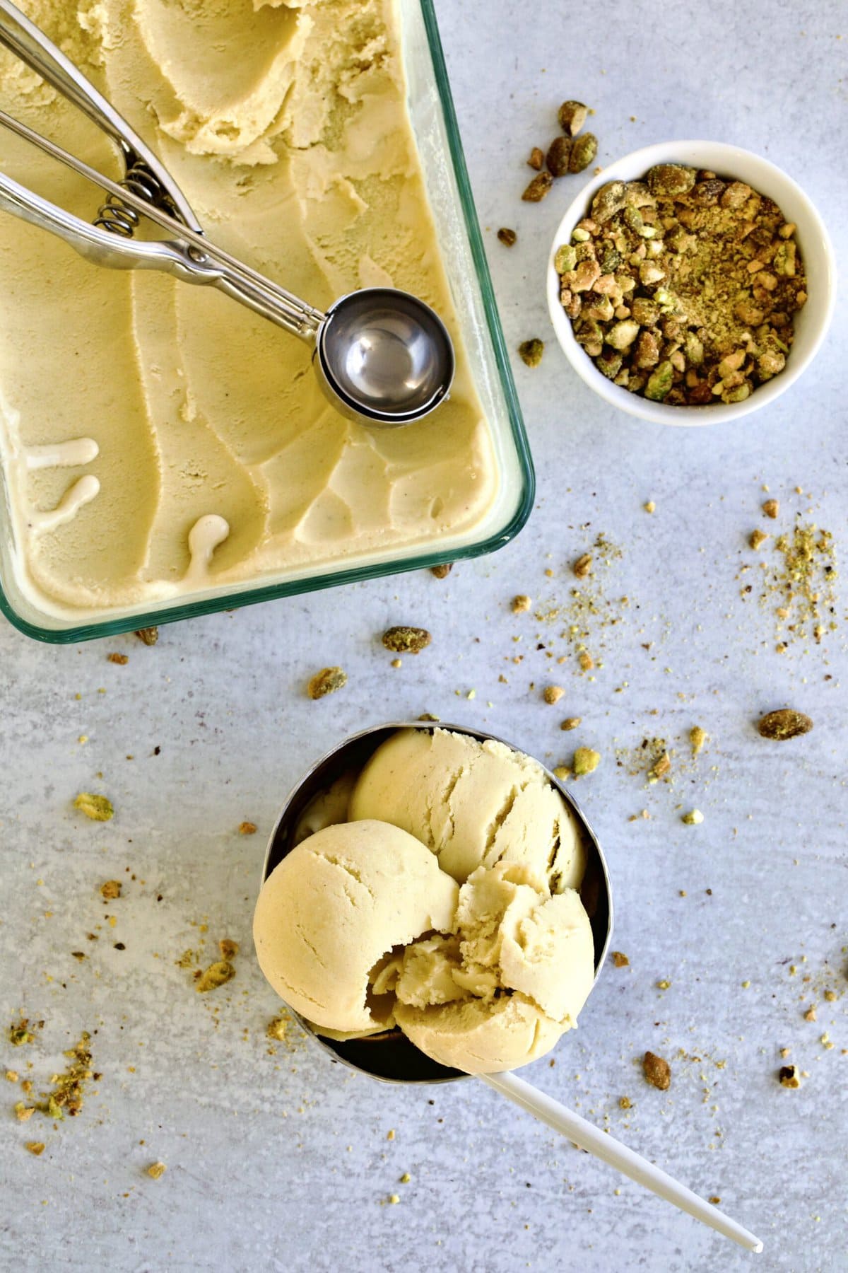 Bowl of pistachio gelato next to more gelato.
