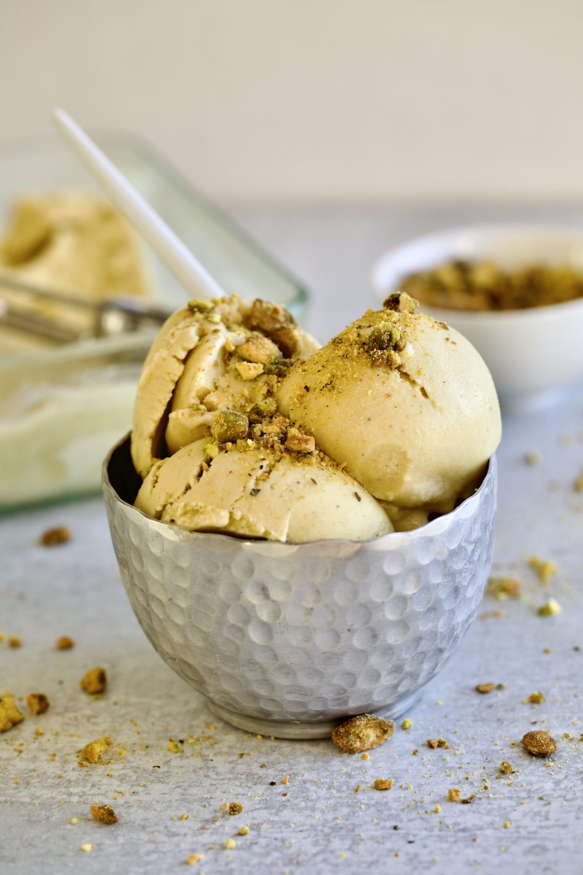 Italian pistachio gelato in a cup with a spoon.