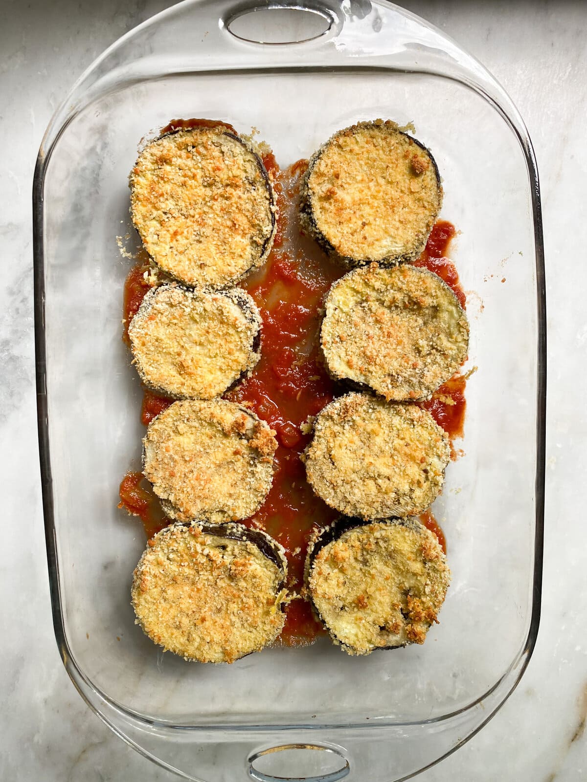 layering the eggplant slices with ricotta and cheese. Repeat layers. 