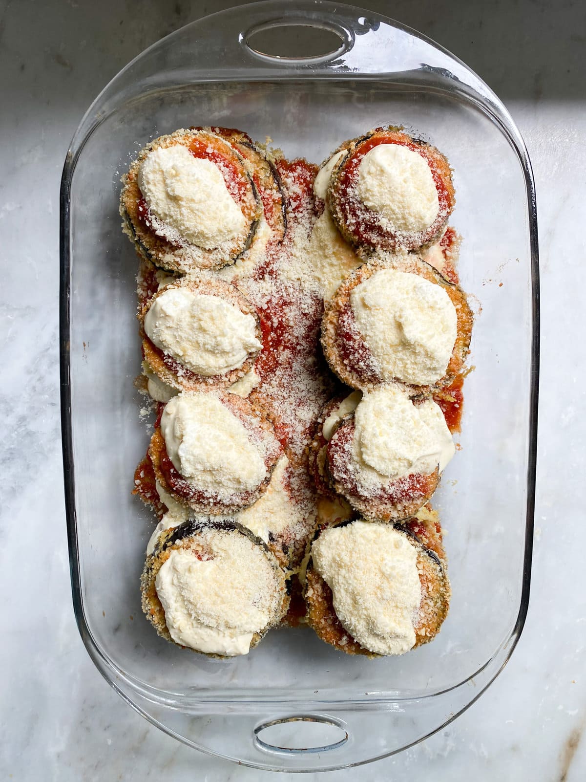 layering the eggplant slices with ricotta and cheese. Repeat layers.