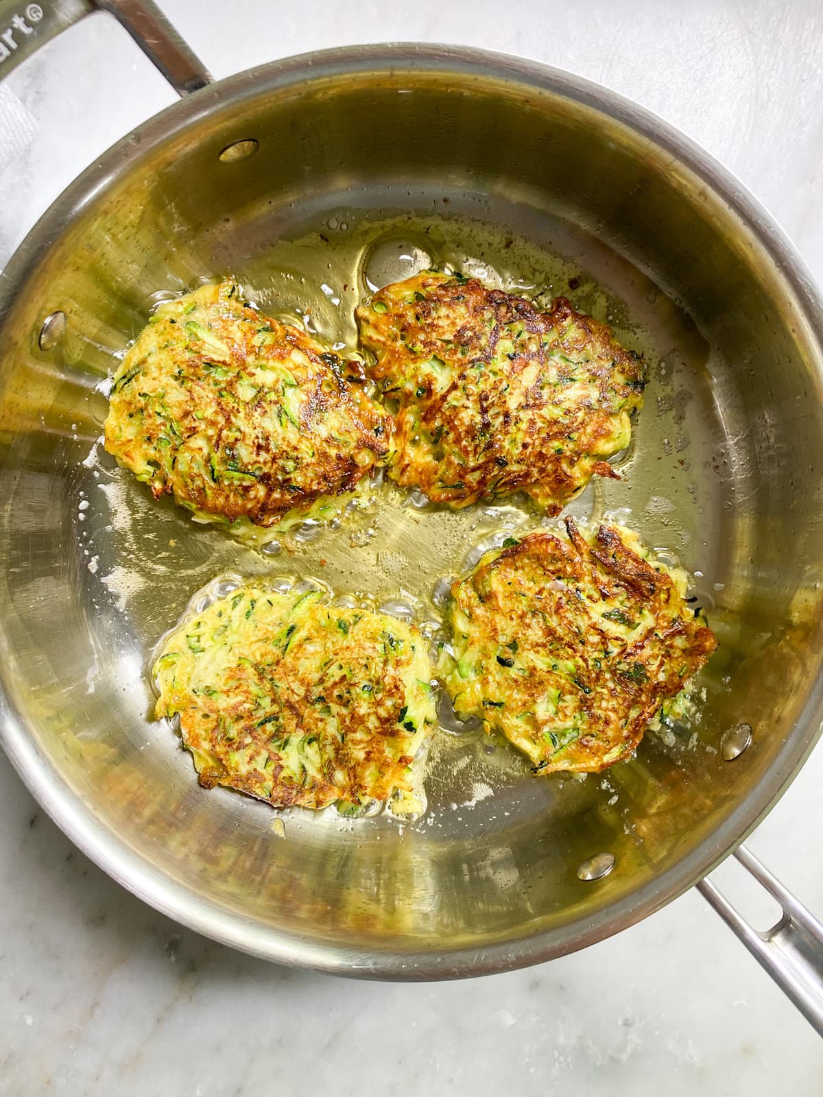 cooking zucchini fritters in pan with oil. Browned on both sides.