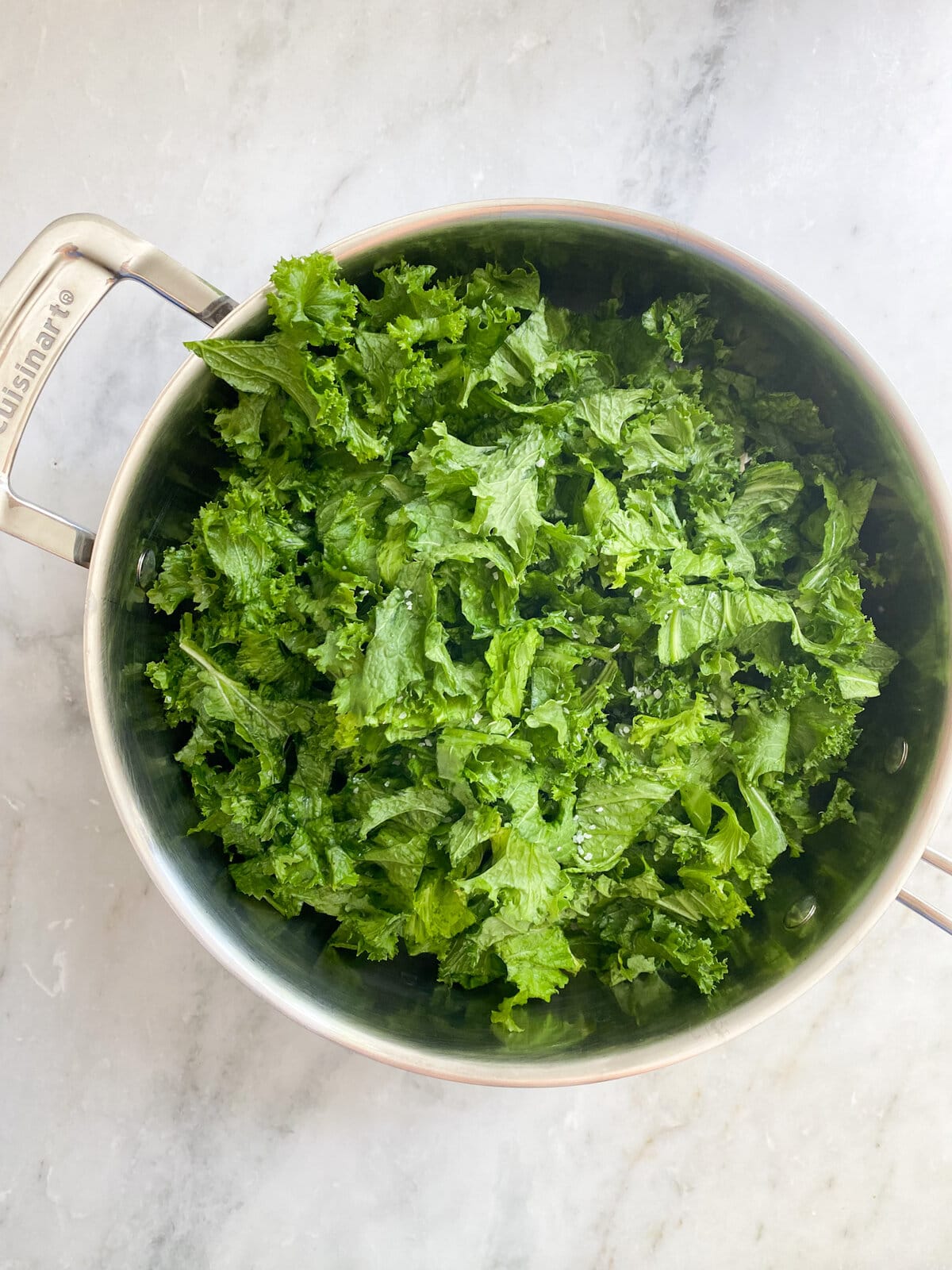 process: adding escarole to pan with garlic and cooking. 