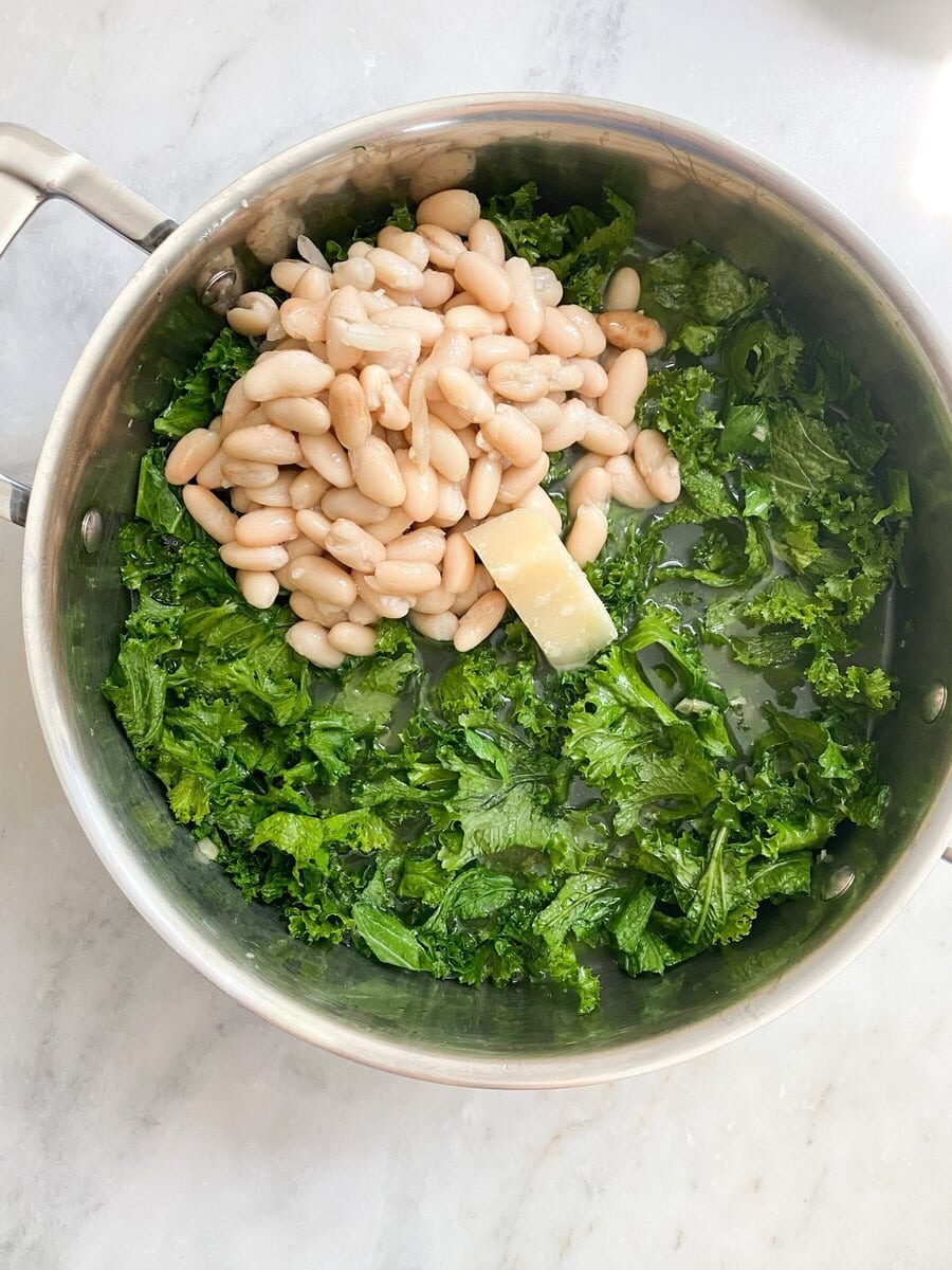 Adding the beans and a chunk of parmigiano parmesan cheese.
