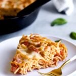 Fork on a plate with a slice of fried spaghetti.