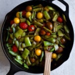 Italian green beans and tomatoes cooked in cast iron pan.