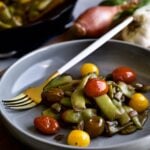 side shot of Italian green beans and tomatoes with a fork ready to eat.