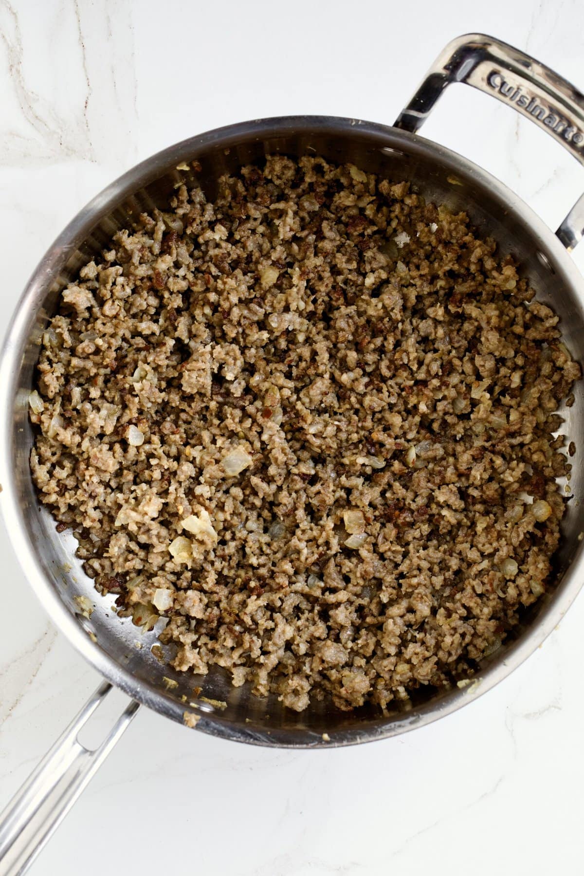 cooking the sausage, onions, and garlic in a skillet