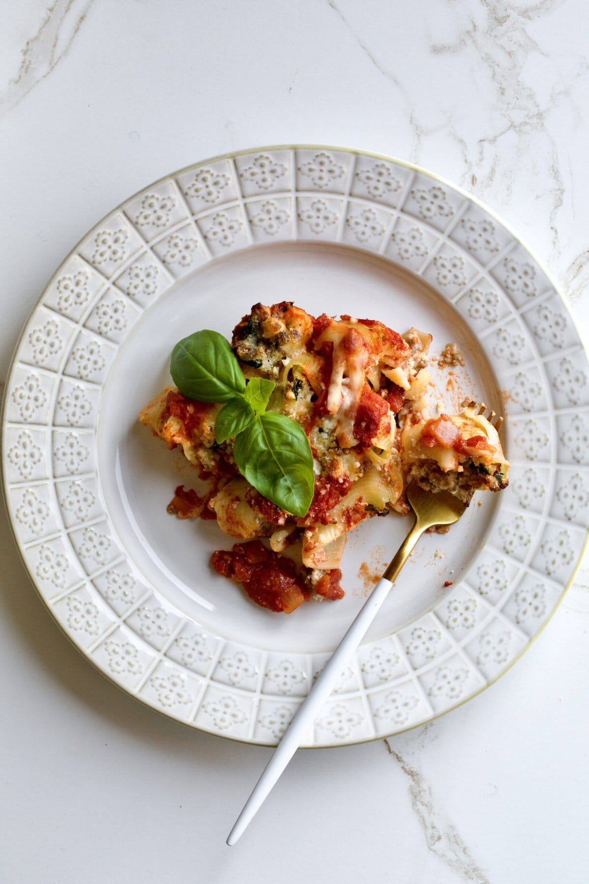 Baked stuffed shells with melted cheese on a plate as a slice.