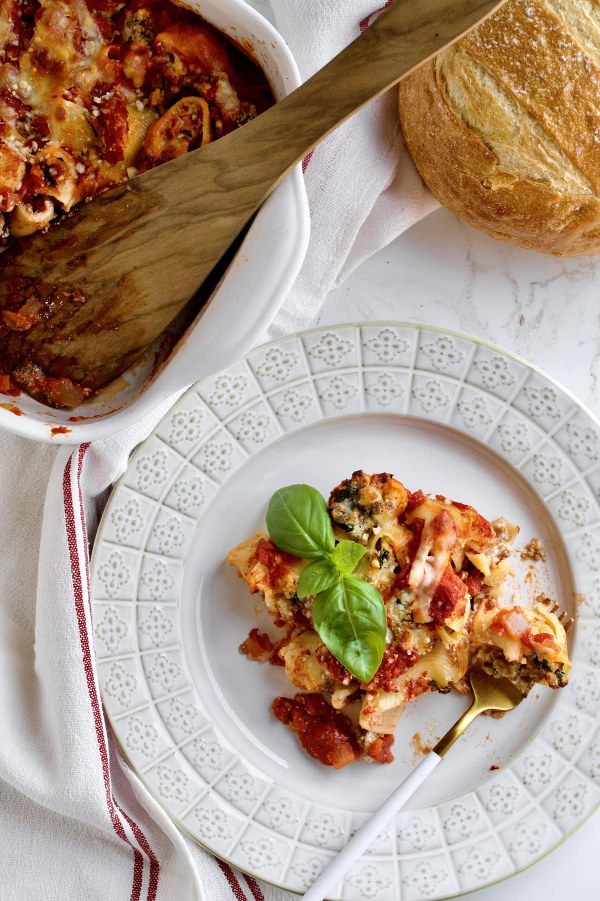 Baked stuffed shells with melted cheese on a plate as a slice.