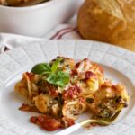 Baked stuffed shells with melted cheese on a plate as a slice.