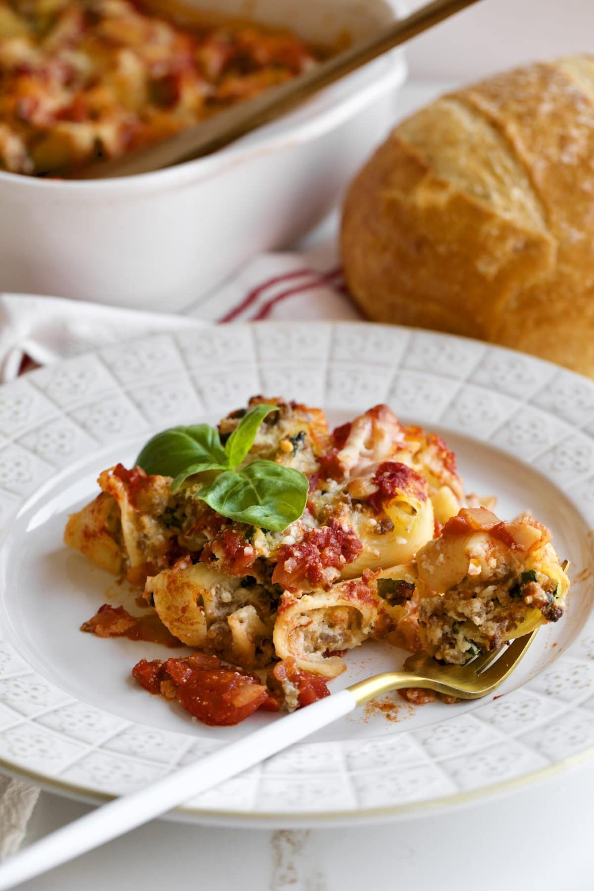 Baked stuffed shells with melted cheese on a plate as a slice.