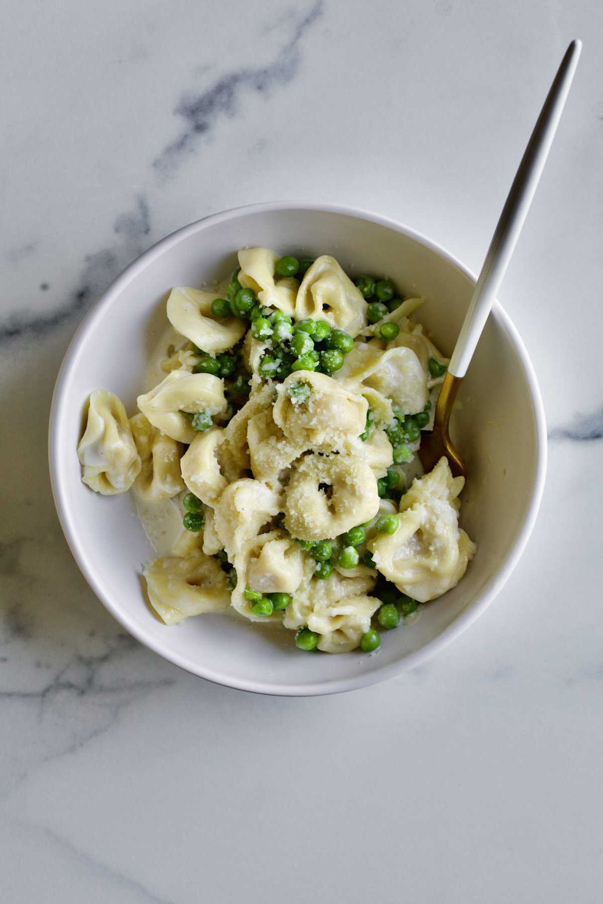 bowl of tortellini alla panna with peas.