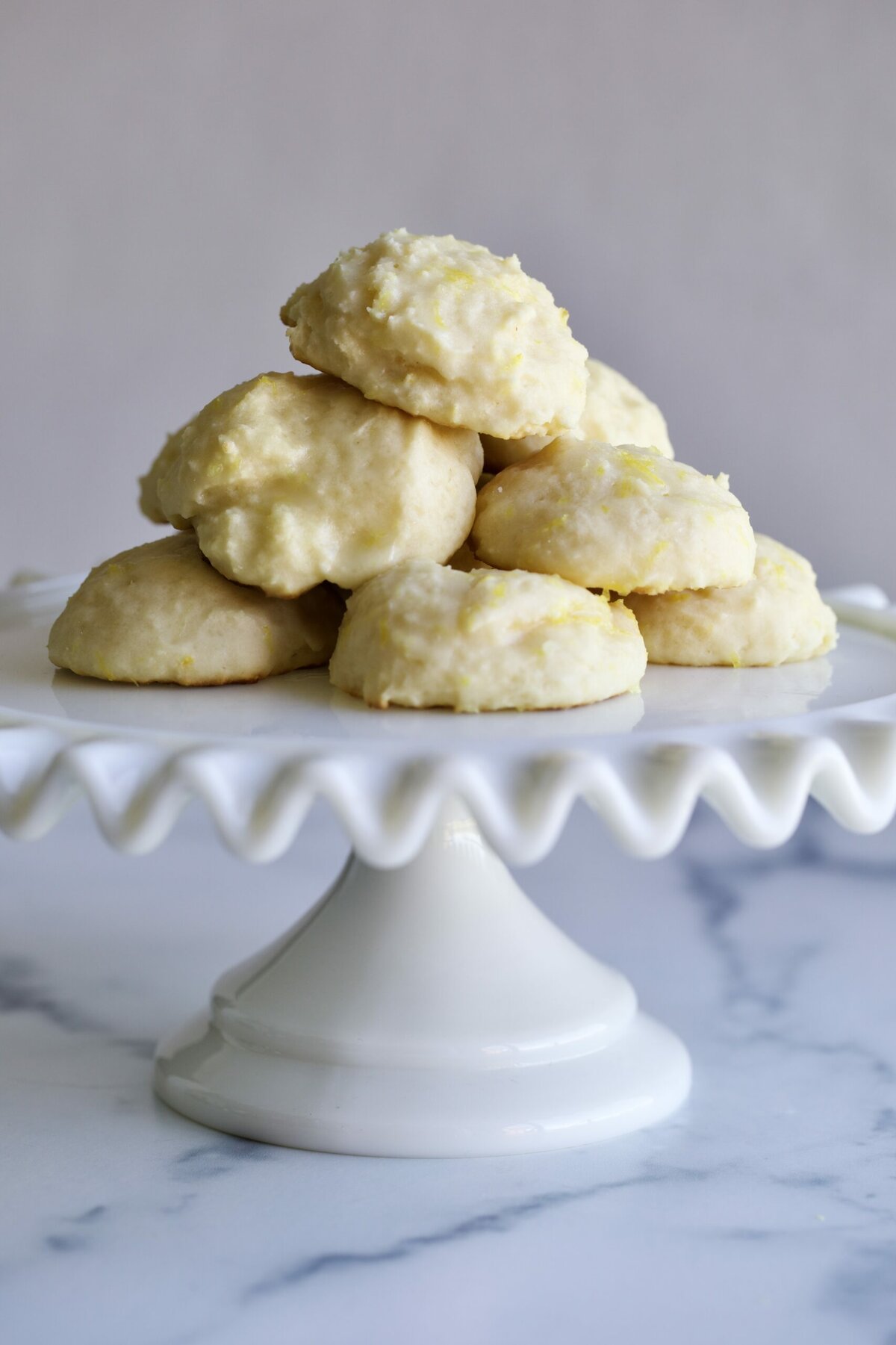 lemon ricotta cookies on a cake plate. 