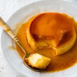 A bite taken out with a spoon from the creme caramel (Italian flan).