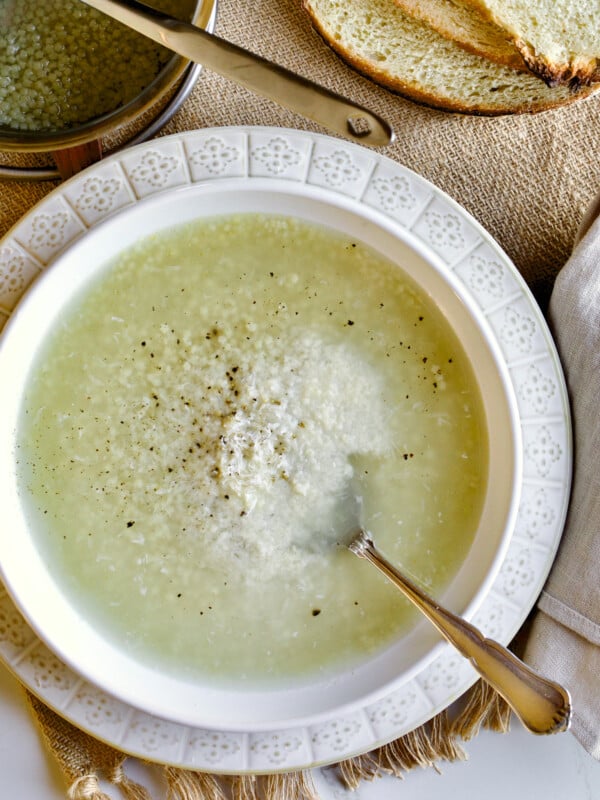 Pastina soup in a white bowl with a silver spoon