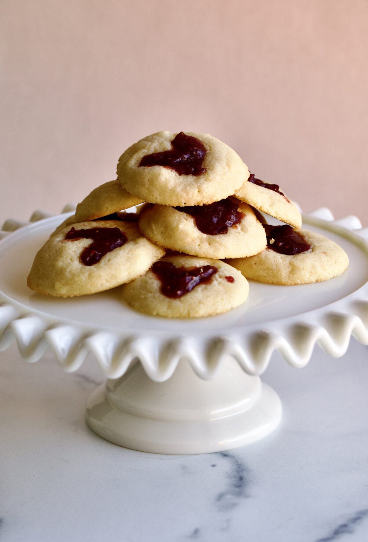 heart shaped cookies on a ruffled cake plate platter. 