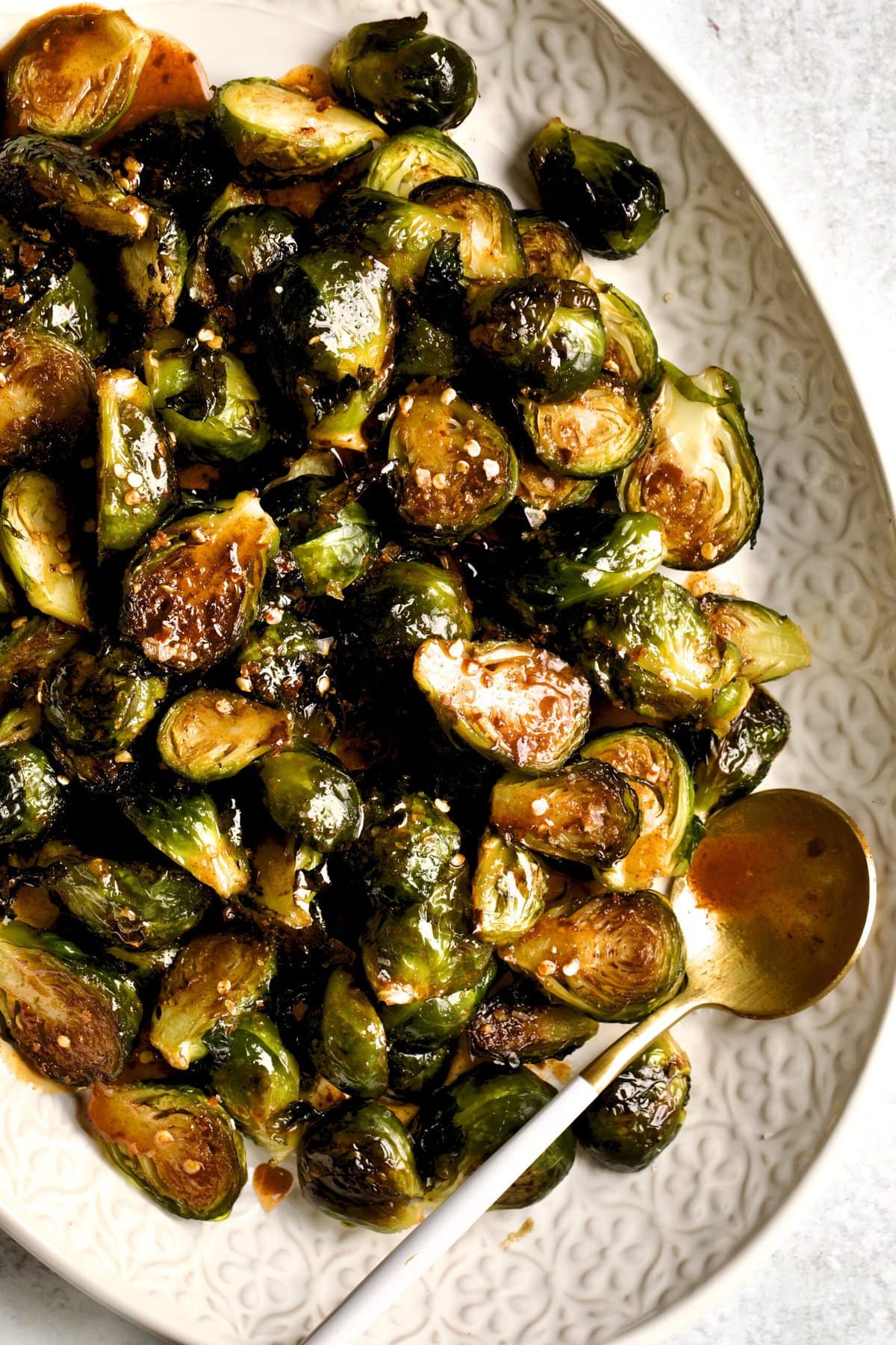 Crispy Brussels Sprouts Recipe on a cream colored serving platter.